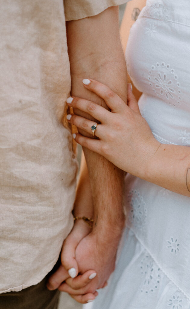 Fiancée holding fiancés arm showing engagement ring at Lake Isabelle