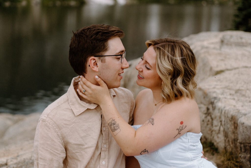 Couple smiling at each other at Lake Isabelle during an engagement session
