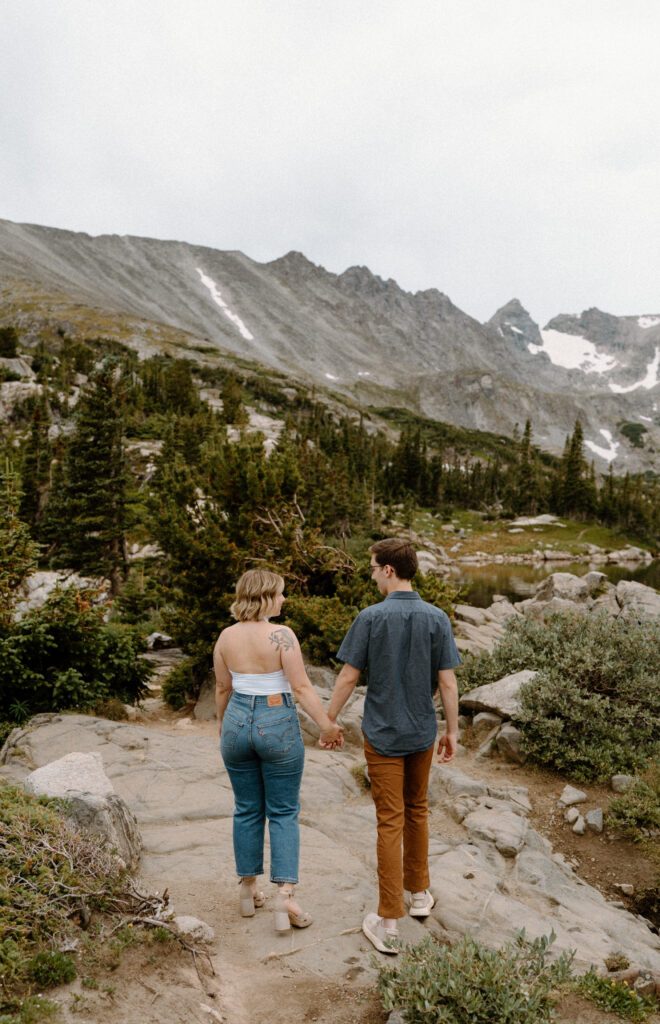 Couple hiking on a path at Lake Isabelle during an engagement session