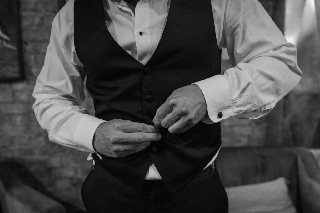 Groom buttoning suit during a wedding at The Manor House