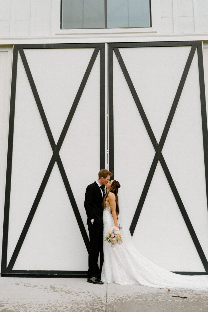 Bride and groom kissing outside of Woodlands on wedding day