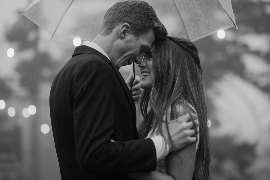 Bride and groom hugging in the rain on wedding day at Woodlands