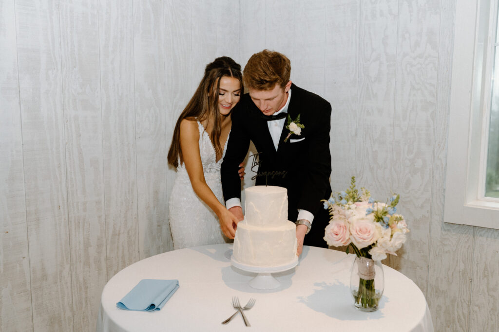 Bride and groom cutting cake on wedding day at Woodlands