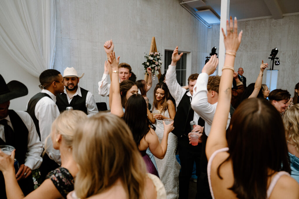 Wedding guests dancing with bride and groom on wedding day at Woodlands