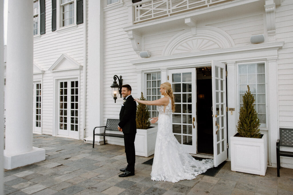 Bride tapping on grooms shoulder during first look at The Manor House