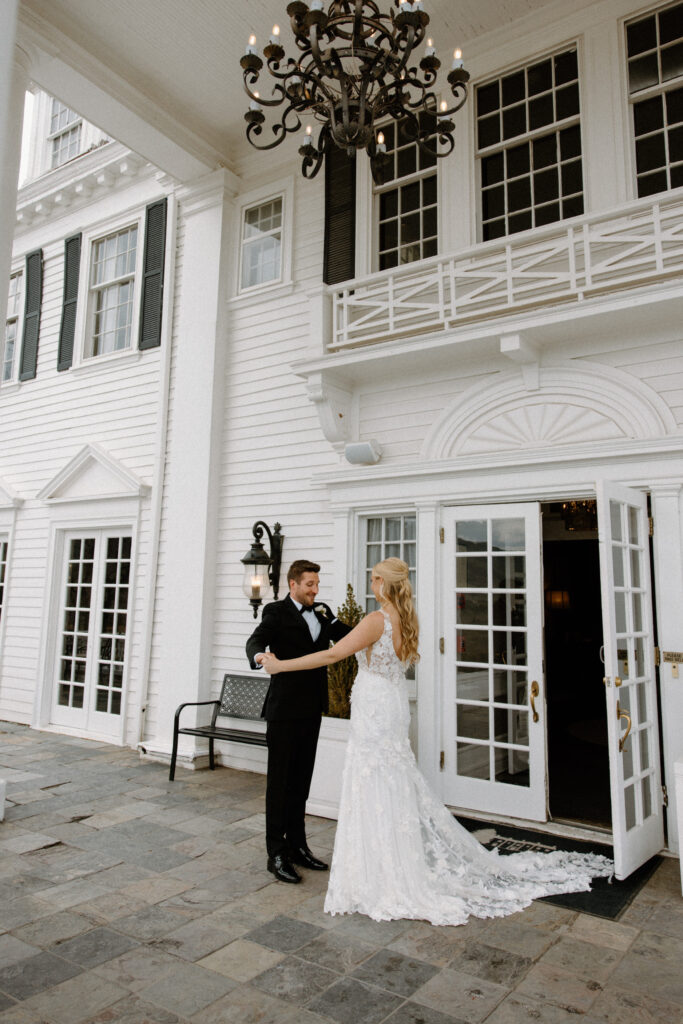 Groom admiring bride's dress during first look at The Manor House