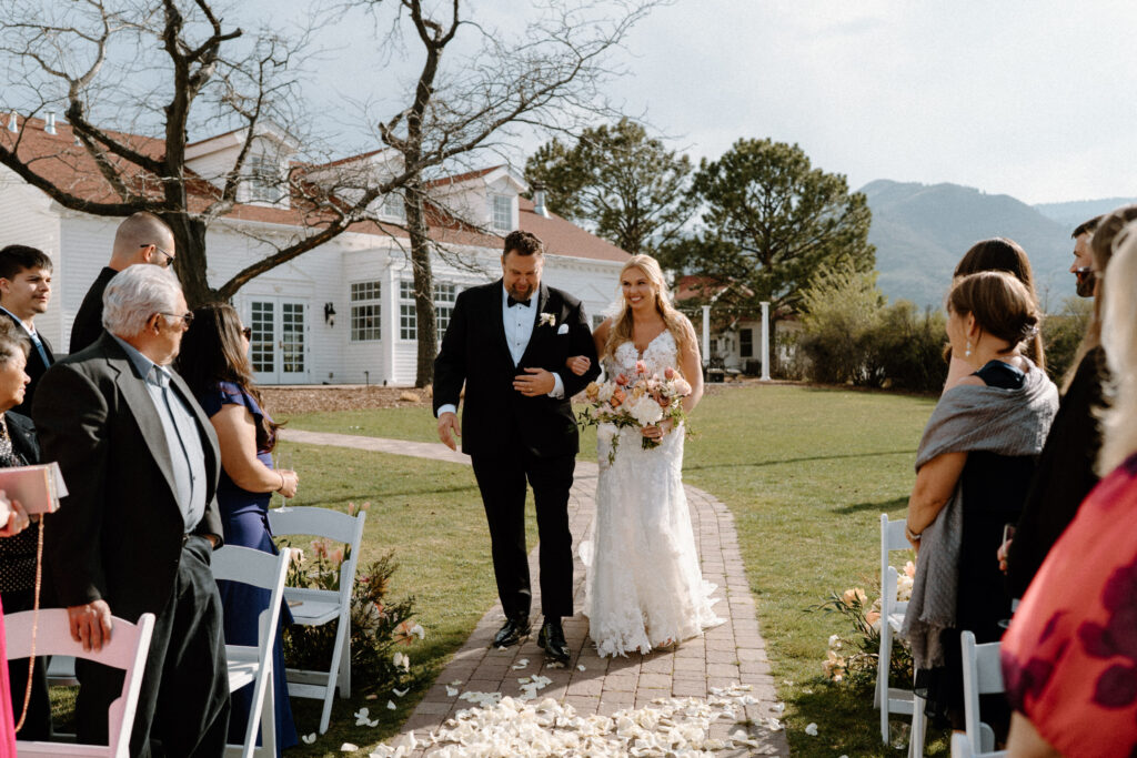 Bride smiling while walking down the aisle on wedding day at The Manor House