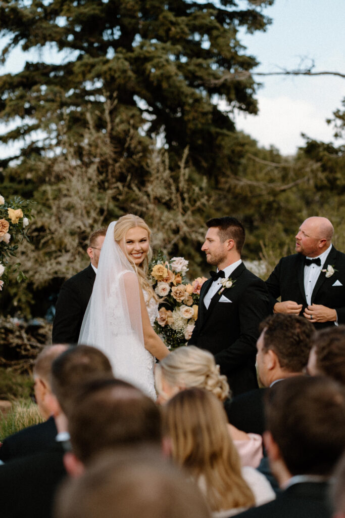 Bride smiling at bridesmaids on wedding day at The Manor House
