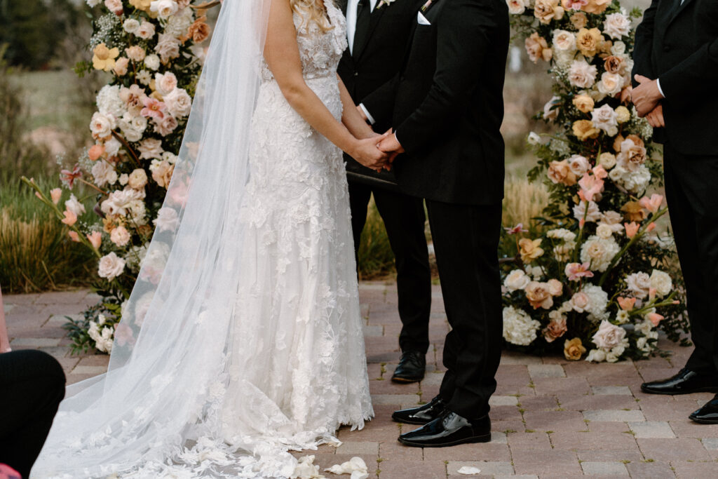 Bride and groom holding hands during ceremony at The Manor House