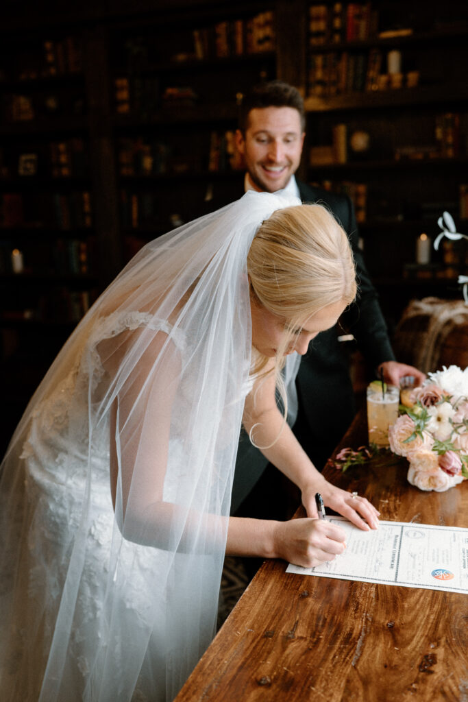 Bride signing marriage license on wedding day at Manor Hose