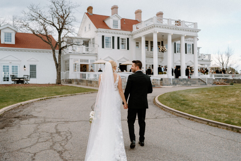 Bride and groom walking to The Manor House on wedding day