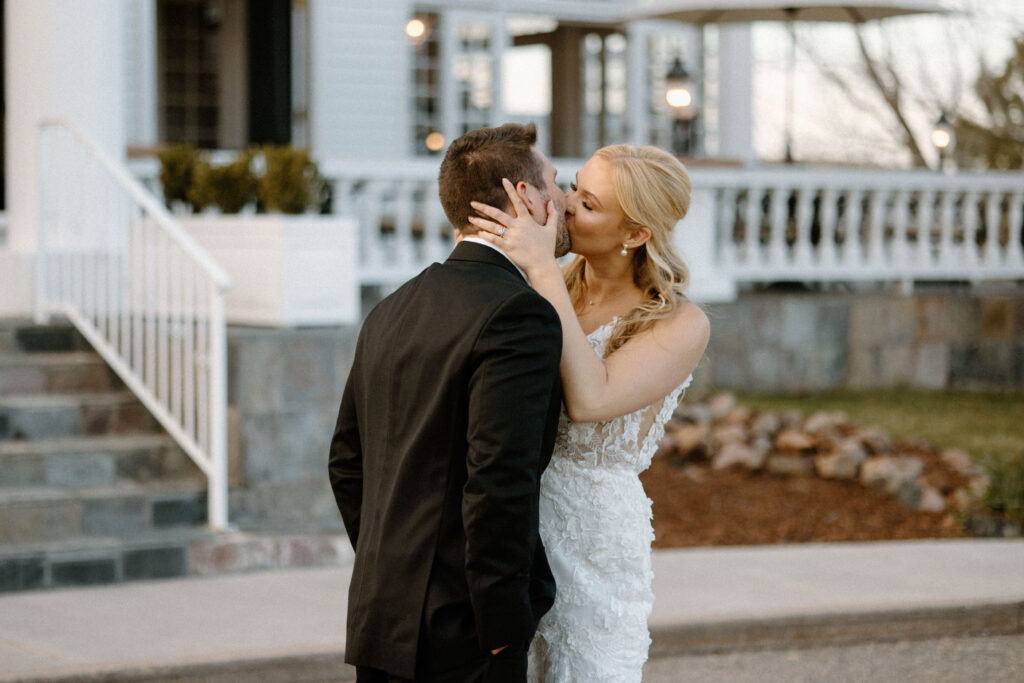 Bride and groom kissing outside Manor House 
