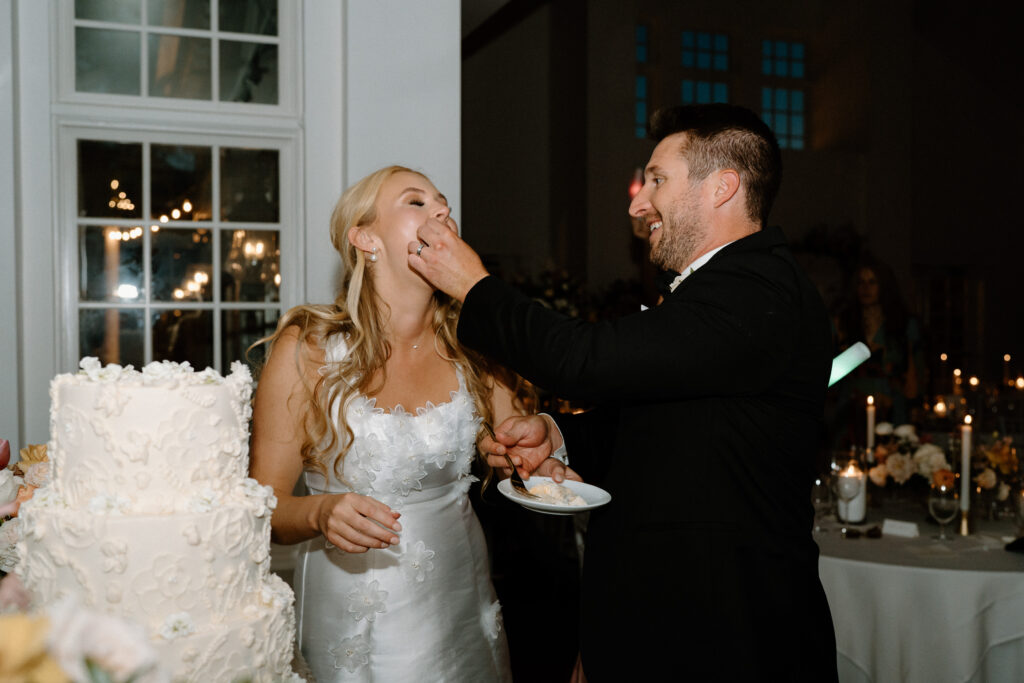 Groom feeding bride cake on wedding day at Manor House