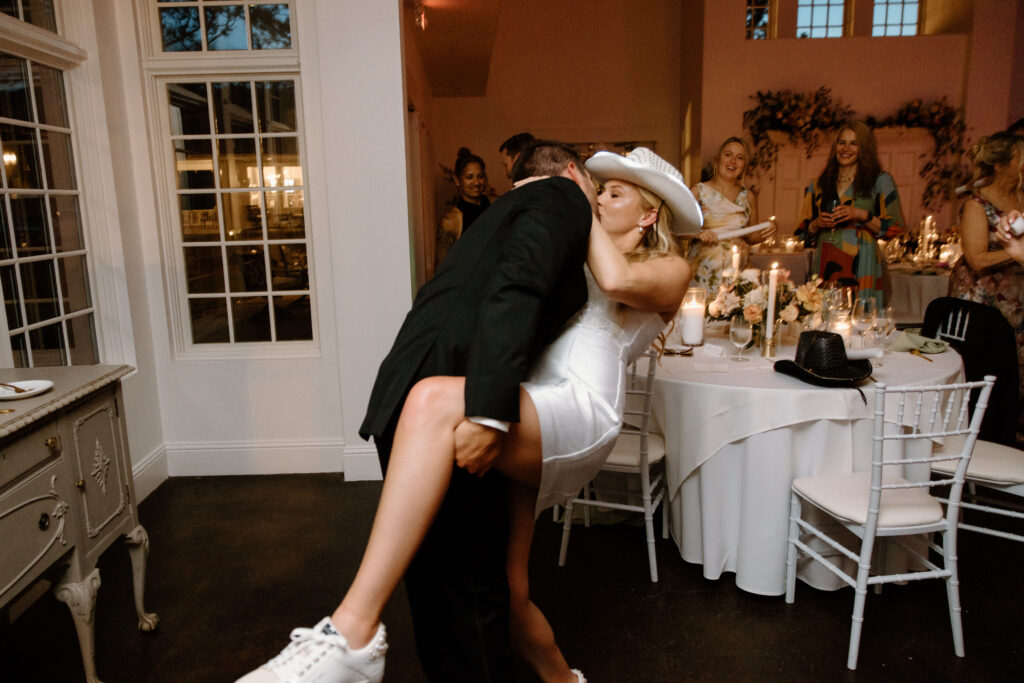 Bride and groom kissing during reception on wedding day at Manor House